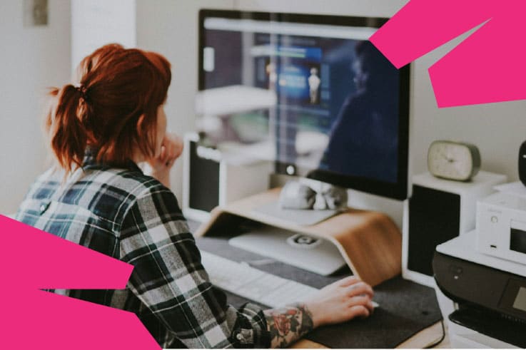 A woman at a website design agency working on a computer